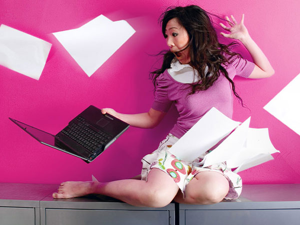 Woman holding laptop while screaming