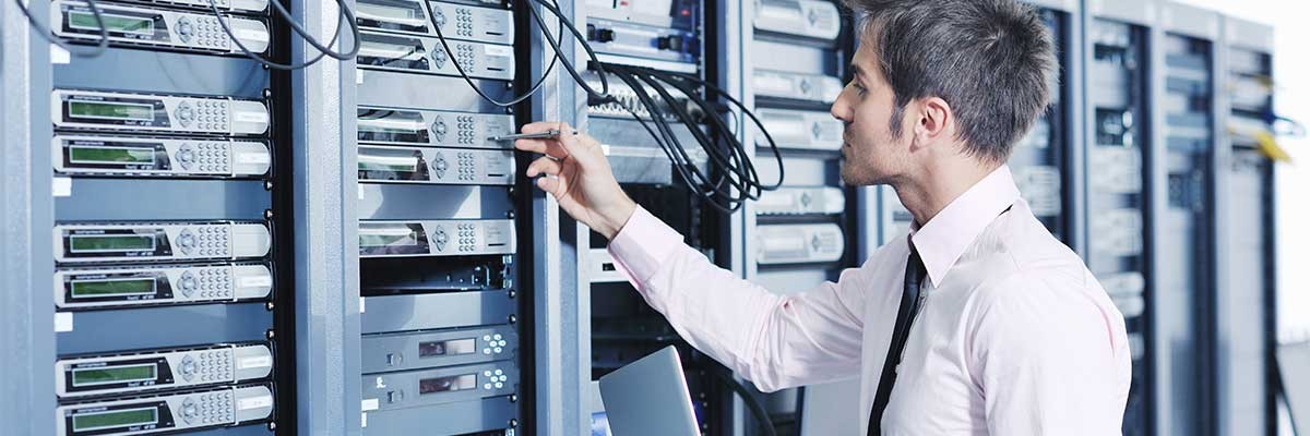 A young technician works in a datacenter