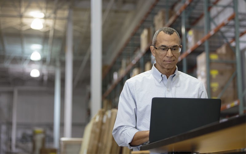 IT operations for business management and solutions Business man working on laptop in warehouse