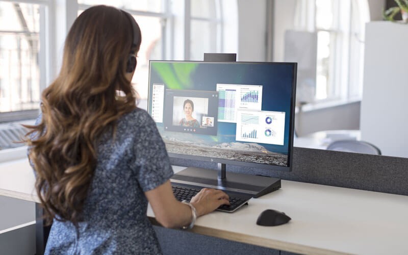 HP all-in-one PCs Woman on call using HP all-in-one PC at desk