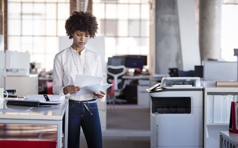 JetAdvantage Security Manager streamlines deployment and monitoring Woman looking through printed documents