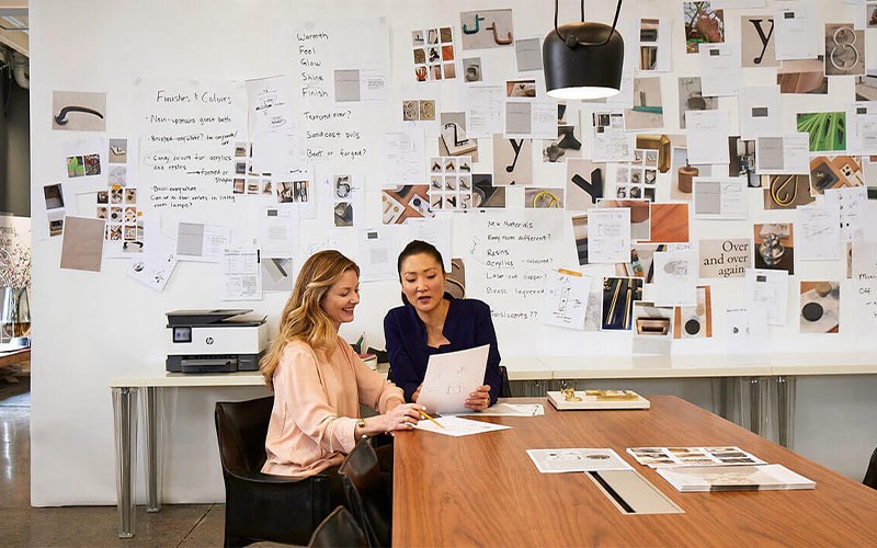 Time your printer did more than just print Two colleagues looking at documents in a meeting