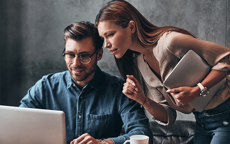 Advanced security from the inside with VMware NSX® Female assisting a colleague with work on a laptop