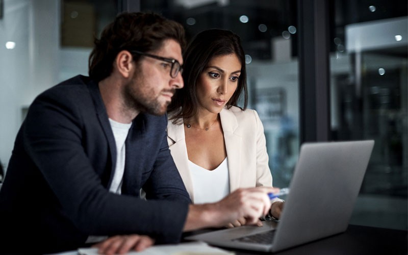 Transformation technology solutions for your organisation Two coworkers looking at laptop device